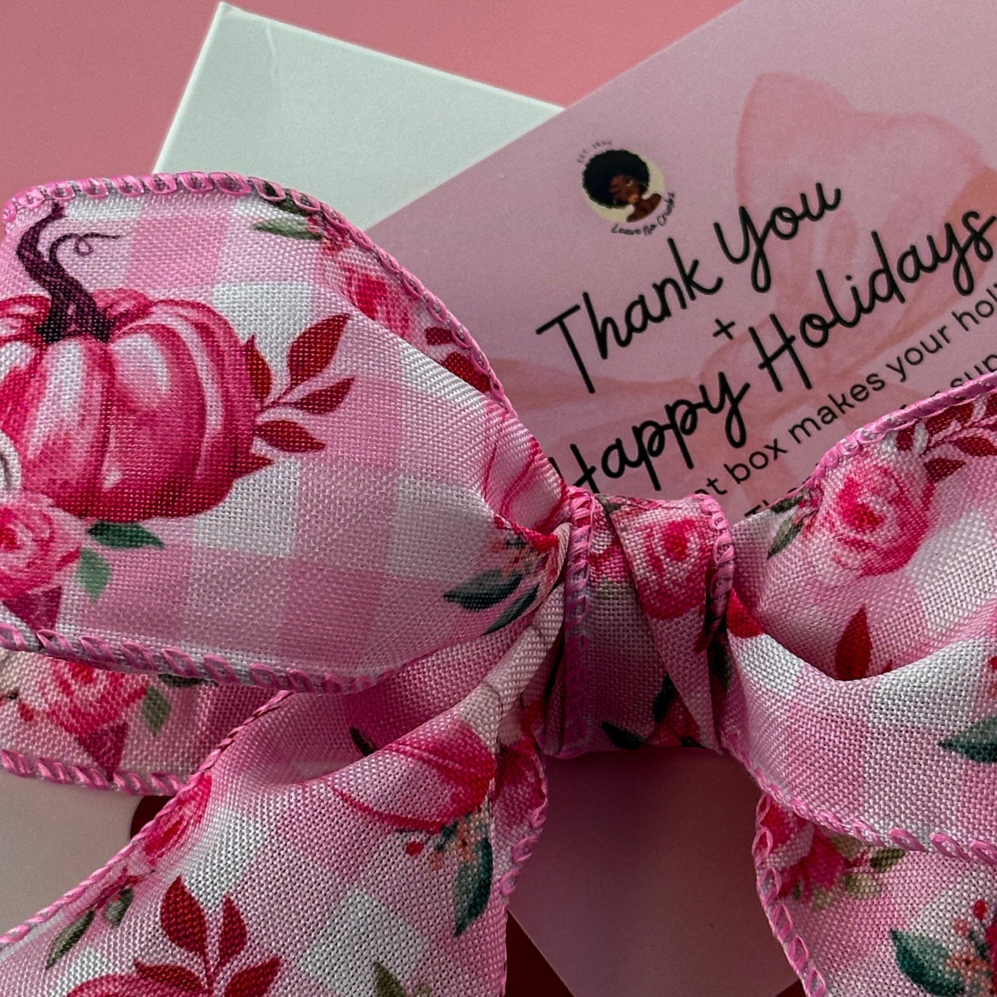 Pink floral bow with a 'Thank You' card on a pink background